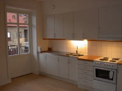 Kök med vita luckor och spis