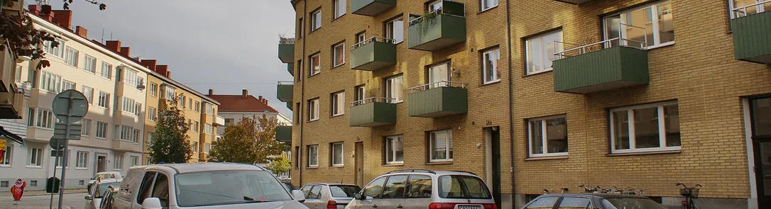 Gult flerbostadshus med balkonger på Carl Hillsgatan i Slottsstaden